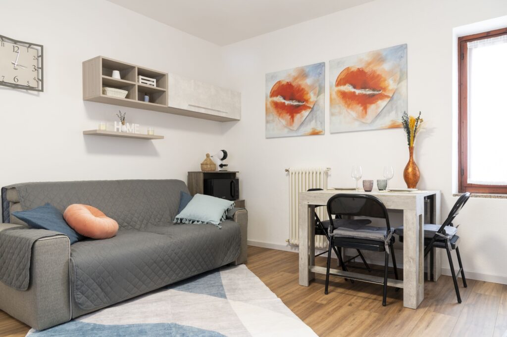 Allestimento home staging ingresso su zona giorno living casa vacanza bilocale